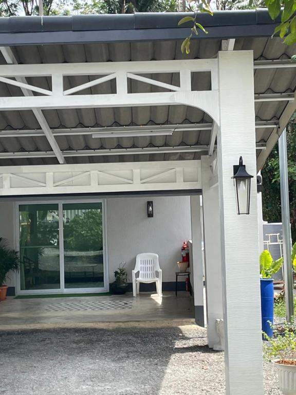 a white pergola with a white bench on a patio at Butterfly Home Mai Khao Phuket in Ban Suan Maphrao