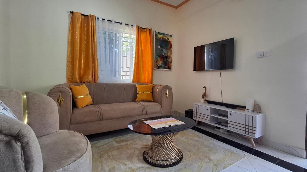 a living room with a couch and a tv at Zai Homes Watamu in Watamu