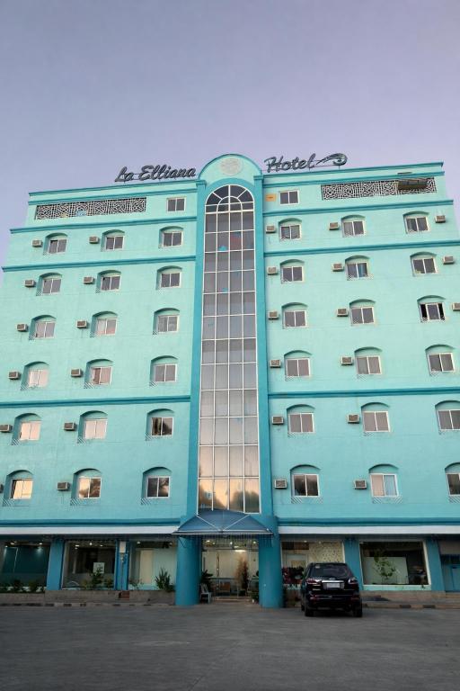 a blue building with a car parked in front of it at La Elliana Hotel & Restaurant, Inc. in Laoag
