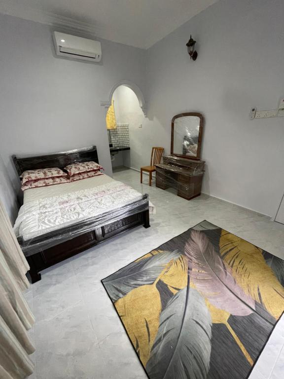 a bedroom with a bed and a mirror on the floor at Wan Guest House in Pasir Mas