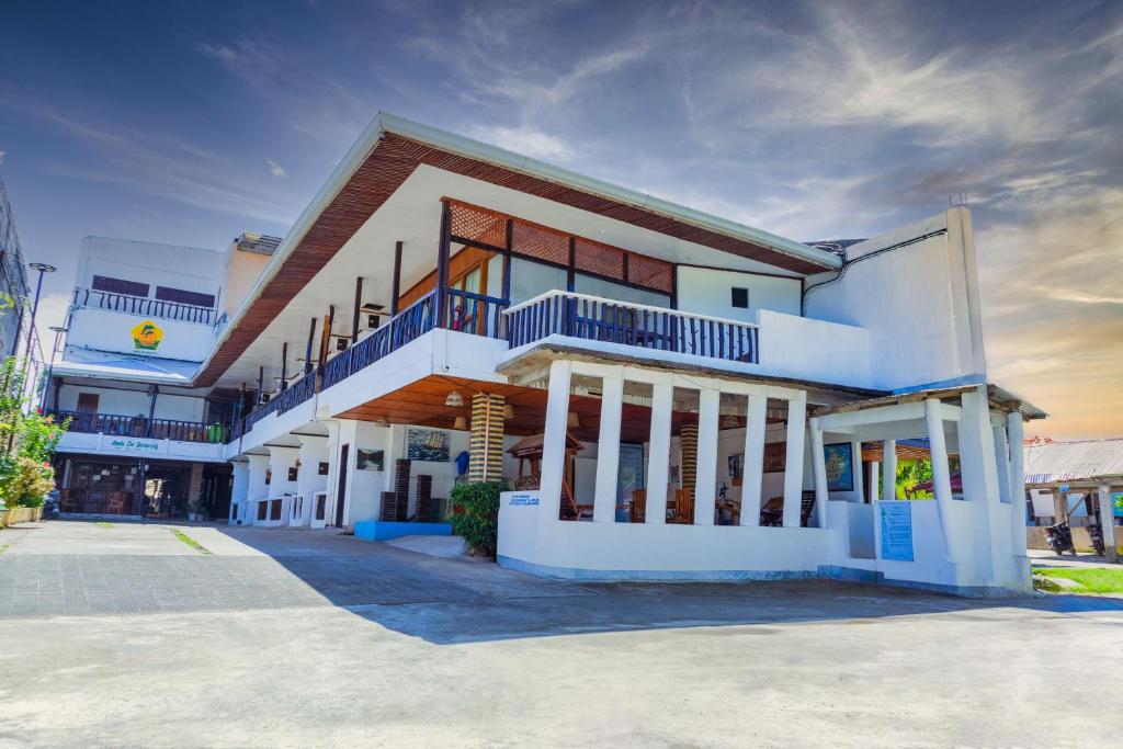 a large white building with balconies on a street at Anda De Boracay White Sand Resort in Anda