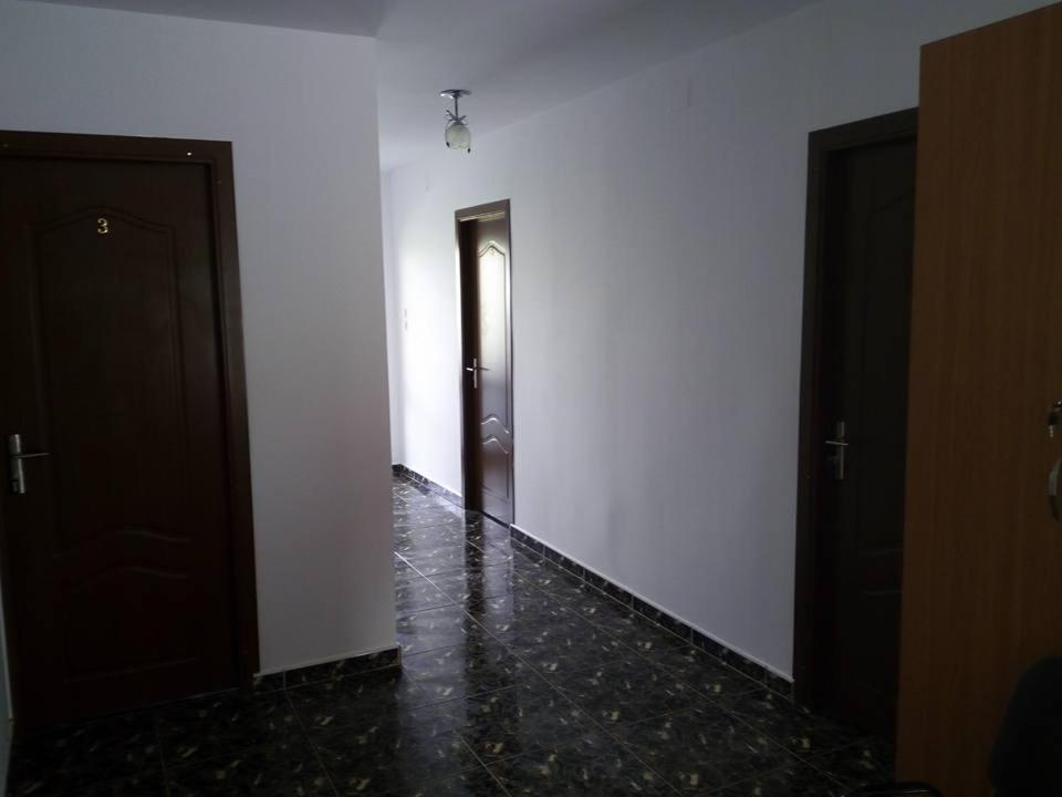 un pasillo vacío con dos puertas y suelo de mármol en Casa Marcone, en Partizanii