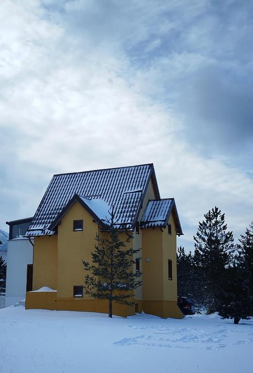 a house with solar panels on it in the snow at Vikend kuća Davor in Risovac