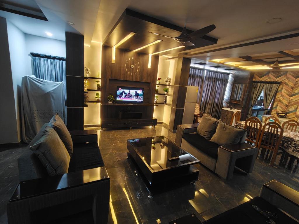 a living room with a couch and a tv at Khaleel Manzil Luxe Stays in Hyderabad