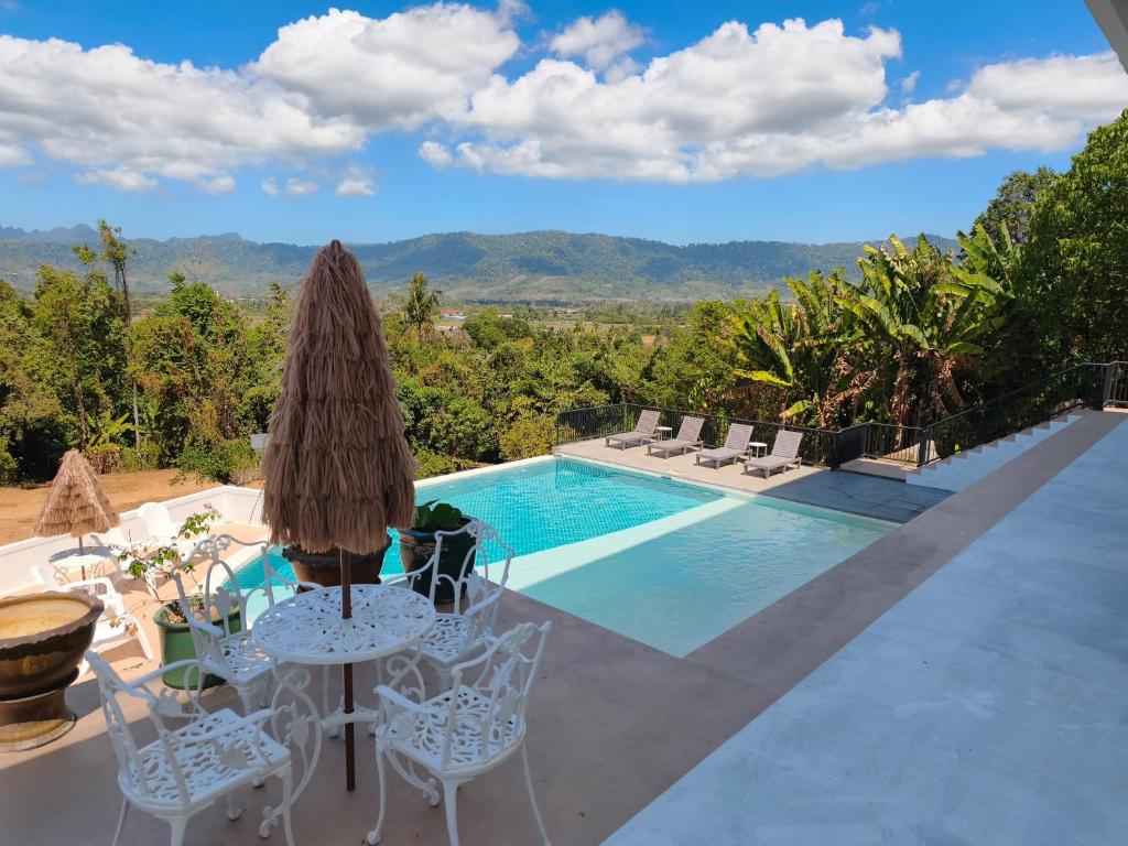 a villa with a pool and a table and chairs at Panoramic View & Spacious with Swimming Pool Aza Sunset Villa 1 in Langkawi Intl