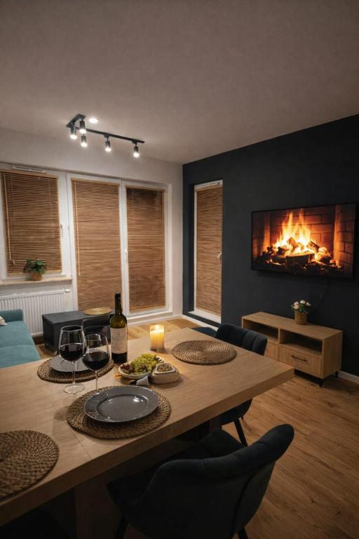 a living room with a table and a fireplace at MODERN APARTAMENT Walendów Park in Walendów