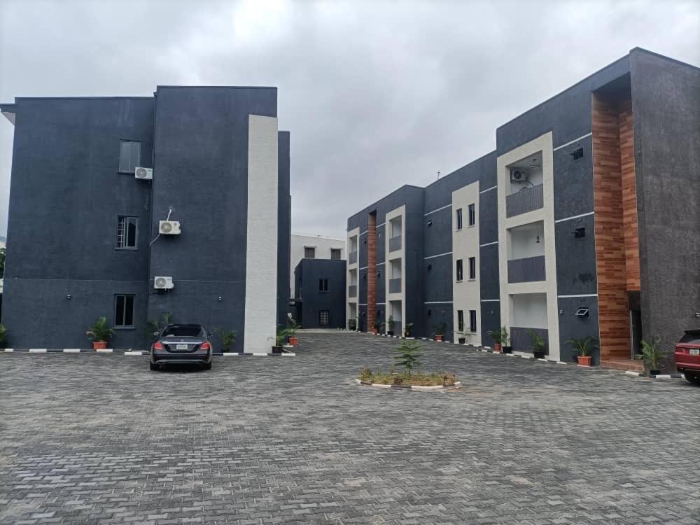a car parked in a parking lot in front of buildings at Emerald Enclave Residence in Gwarinpa