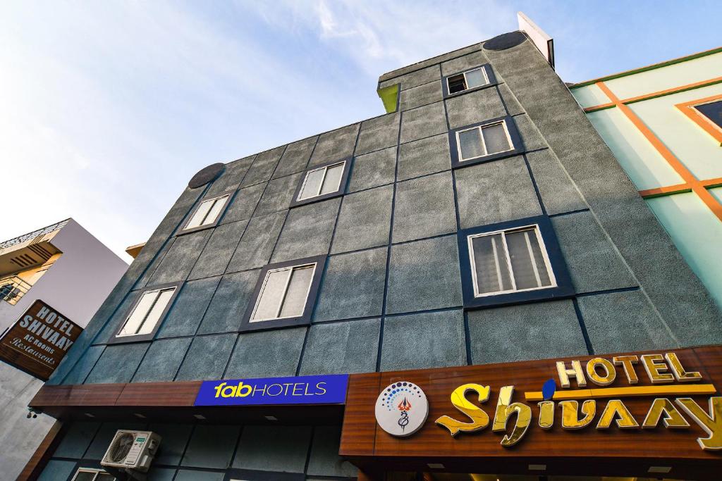 a building with a clock on the side of it at FabHotel Shivay in Indore