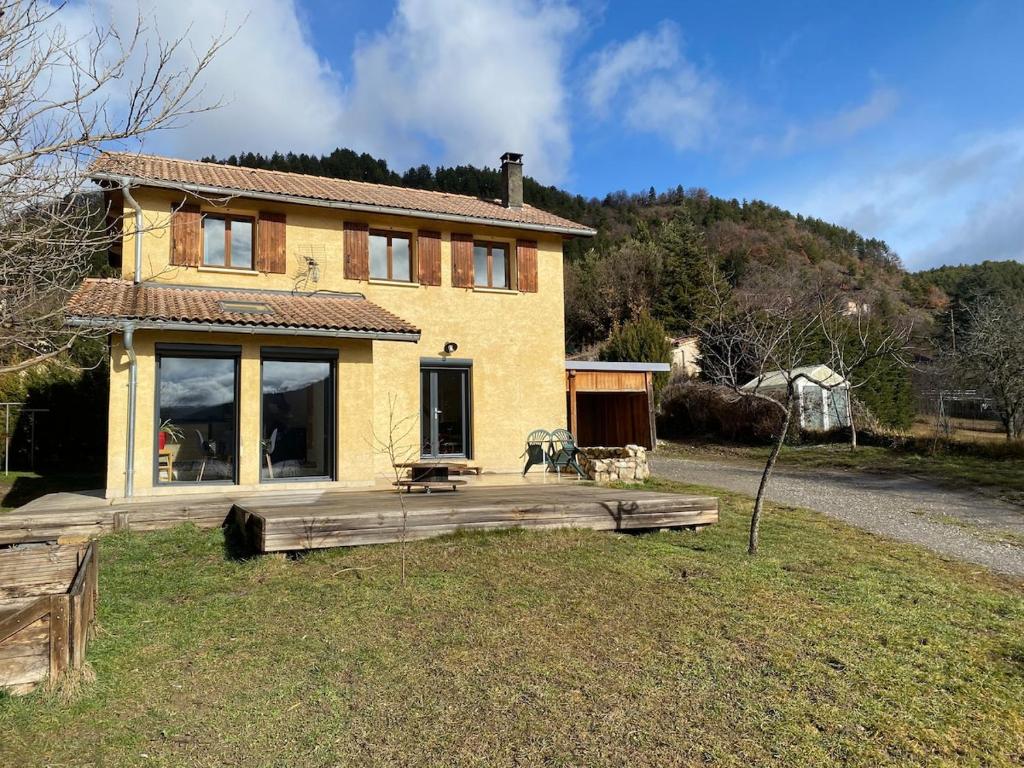 a house with a wooden deck in front of it at La Villa Soleil in Veynes
