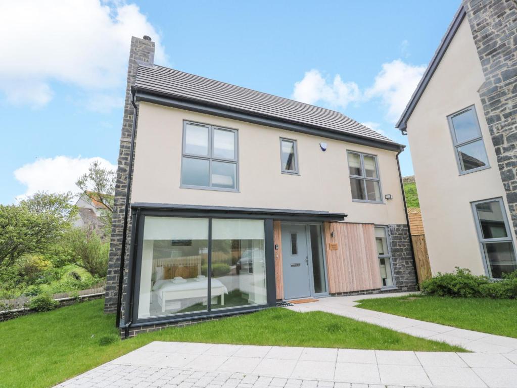 a white house with large glass windows at Summer Rose in Craster