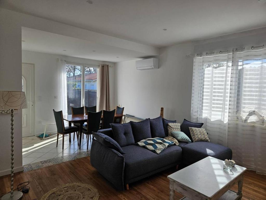a living room with a blue couch and a table at La Belle des Pins in Mimizan
