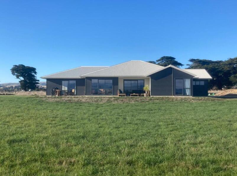 a house in a field with a large yard at Mahaki Escape in Pahautea