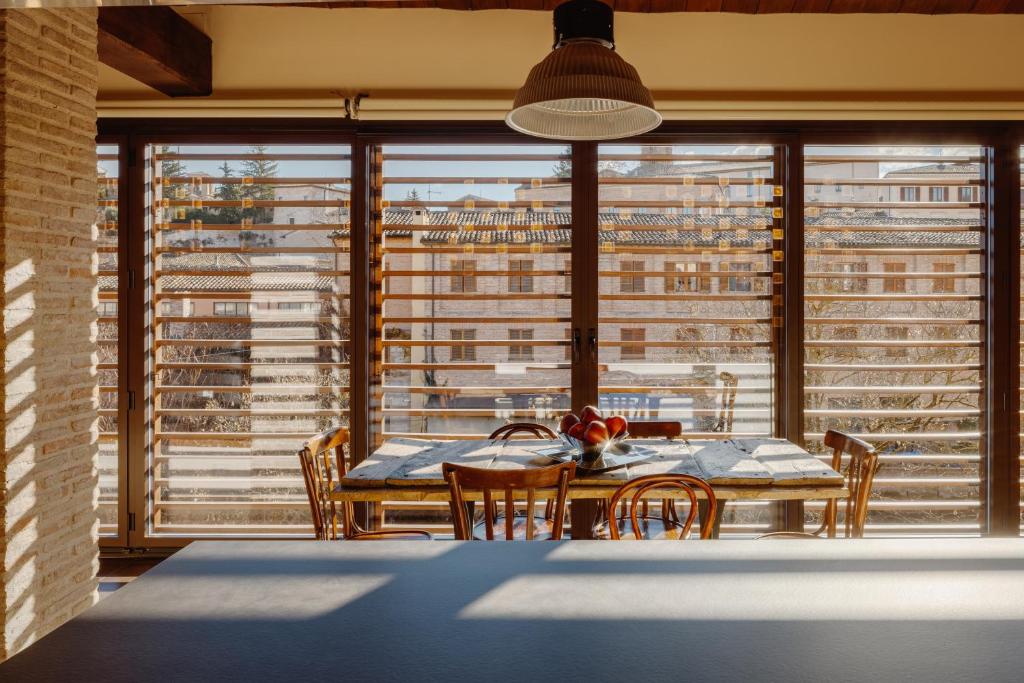 ein Esszimmer mit Tisch und Stühlen und einem großen Fenster in der Unterkunft Dimora Le Conce - Loft di Charme in Fabriano
