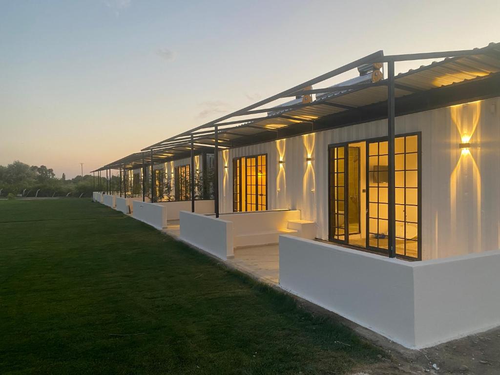 a white building with windows and a grass field at Casamora in Edremit