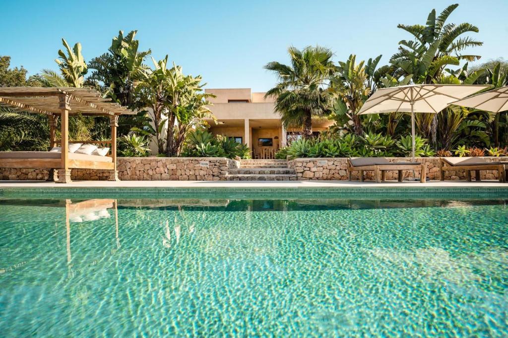 a swimming pool with an umbrella and a resort at Villa Sirio in Cala de Bou