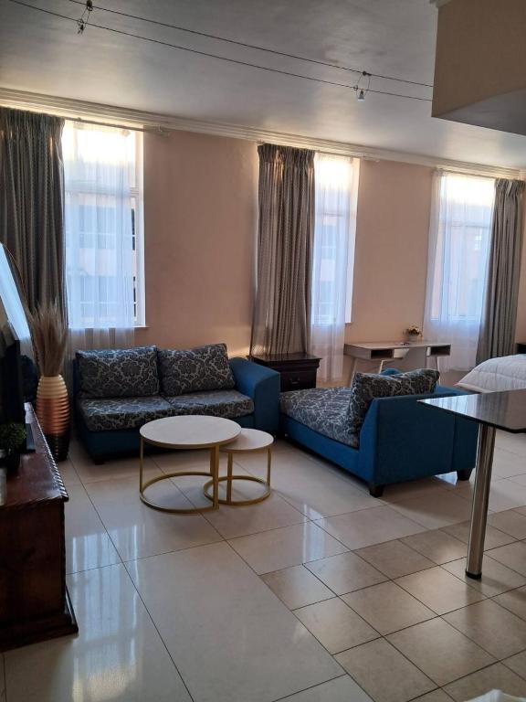 a living room with a blue couch and a table at Mapungubwe hotel unit 525 in Johannesburg