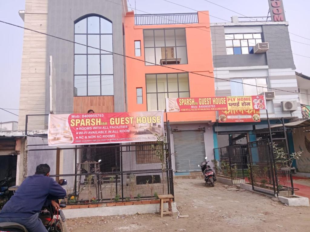 a man riding a motorcycle in front of a building at Sparsh Inn Hotel & Geust House in Gorakhpur