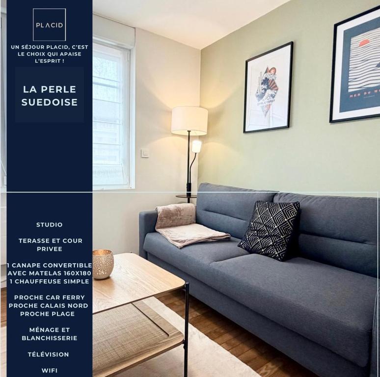 a living room with a blue couch and a table at La perle suedoise - Studio avec terrasse et cour privée in Calais
