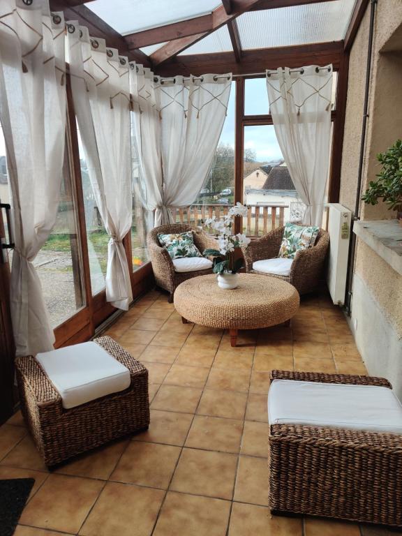 a patio with wicker chairs and a table on a patio at Maison de campagne in Le Puy