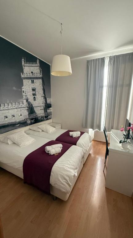 a bedroom with a large bed and a picture of a building at Lisboa II Hotel Restaurant in Luxembourg
