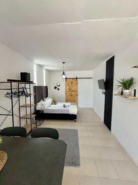 a bedroom with a bed and a room with a couch at Angel's Cottage Unit 1 in Paarl