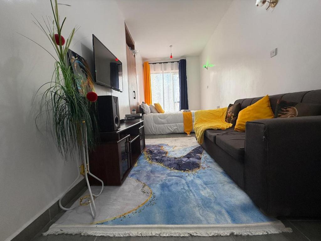 a living room with a couch and a tv at Shooting Stars Homes in Gatunga