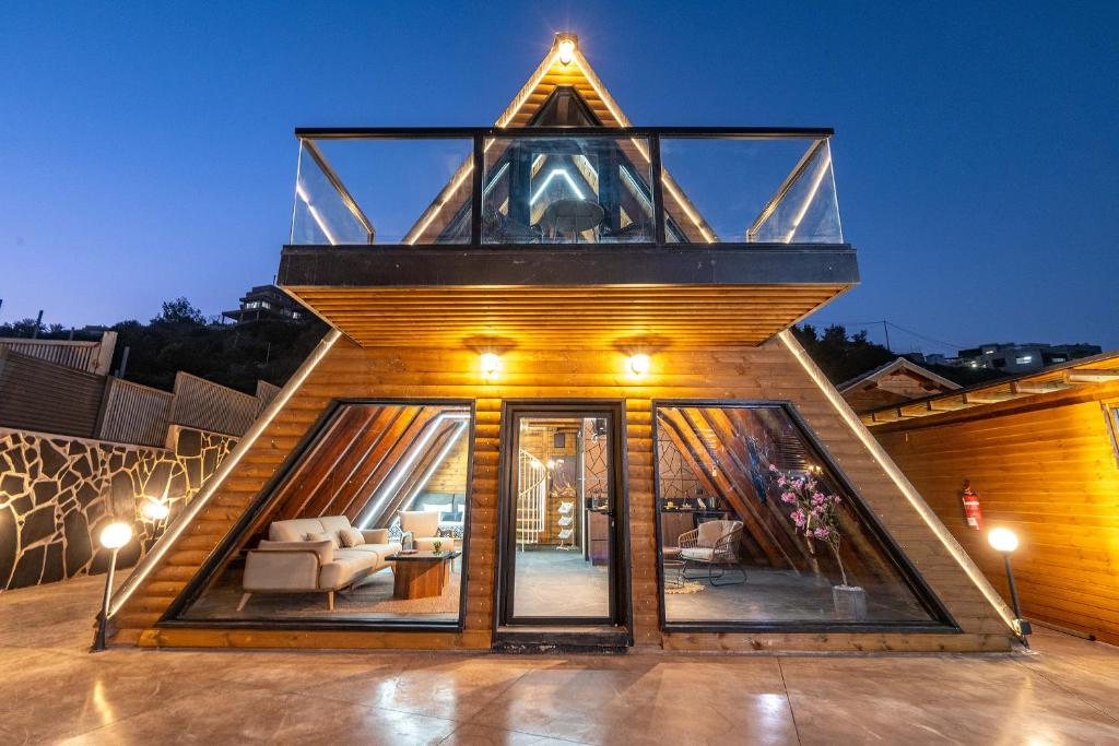 a house with a glass roof with a living room at Wood & Soul - בקתות משולשות מיוחדות עם בריכה פרטית in ‘Isfiyā