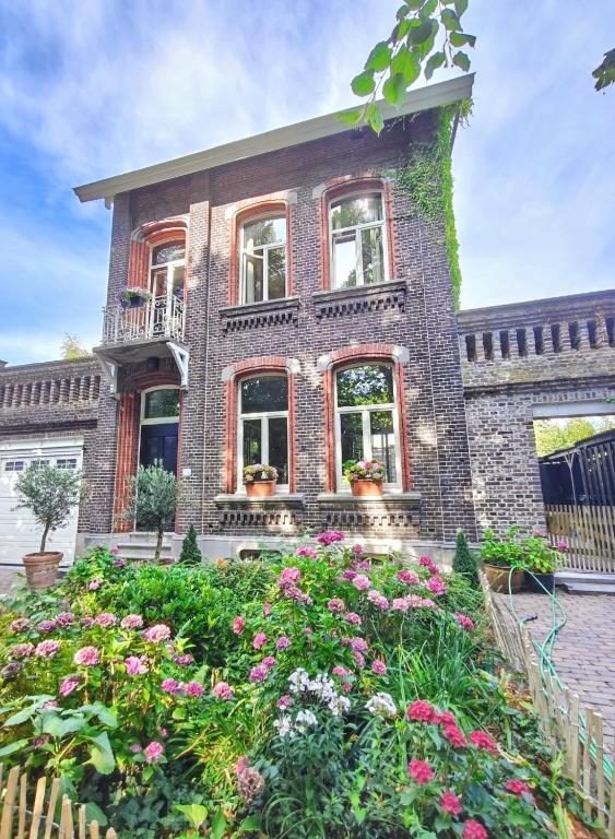 a brick house with flowers in front of it at 't Herenhoes in Neerpelt