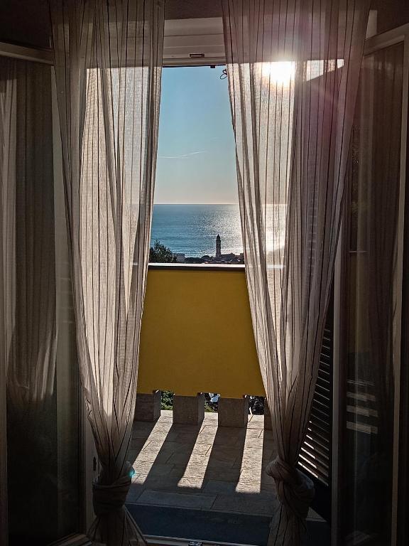 a room with a view of the ocean from a window at Vento di Mare - Tramontana con piscina in Moneglia