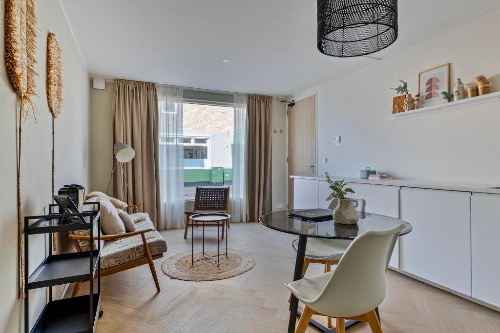 a kitchen and living room with a table and chairs at DuoSuite Sand Vrouwenpolder in Vrouwenpolder