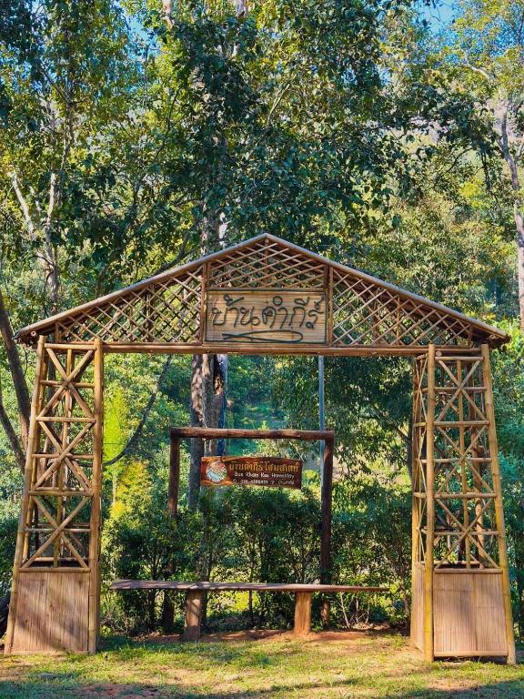 a wooden structure with writing on it in a park at Ban Kham Kee Homestay in Chiang Mai