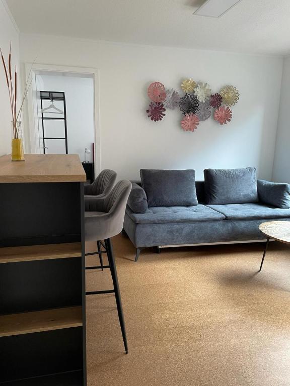 a living room with a blue couch and a table at Bad Salzdetfurth Gästewohnungen in Bad Salzdetfurth
