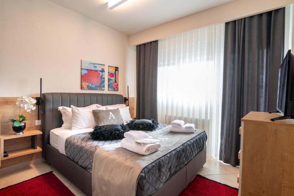 a bedroom with a bed with towels on it at ALEXANDRA Boutique Residence Seaside in Alexandroupoli
