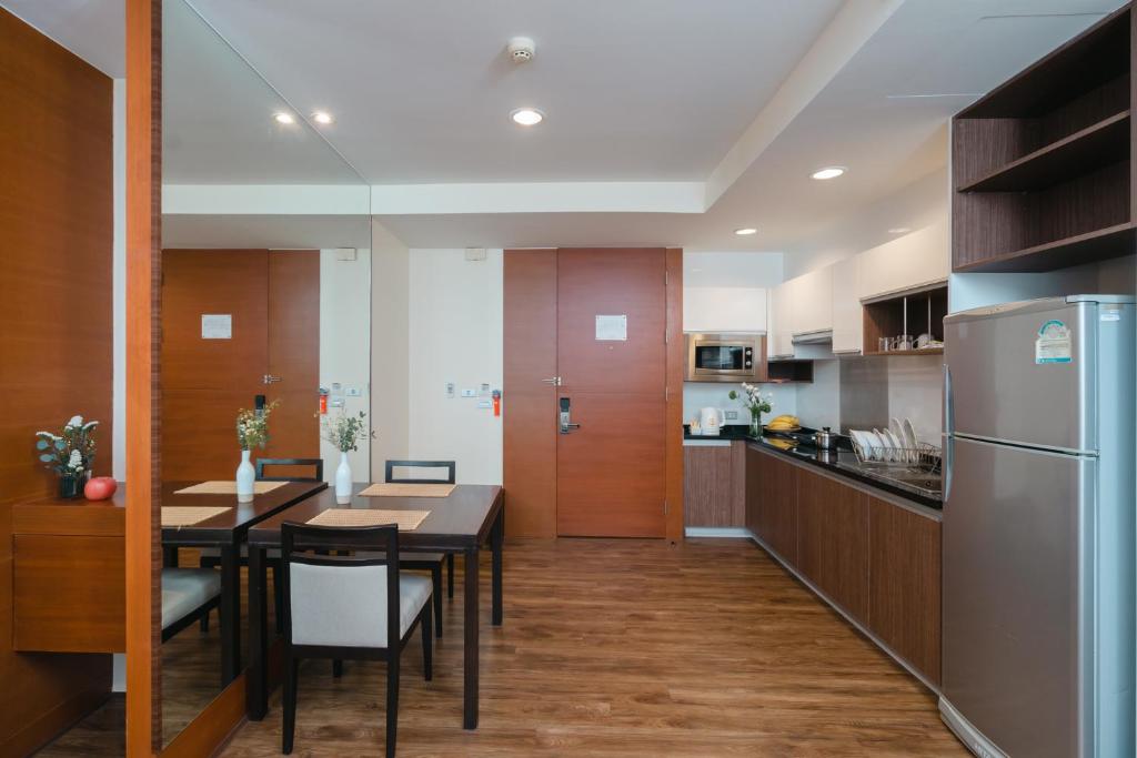 An open-plan residence combines a dining table with a full kitchen and refrigerator.