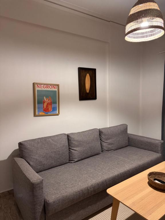 a living room with a gray couch and a table at Psani 50m2 apartment in Nafpaktos