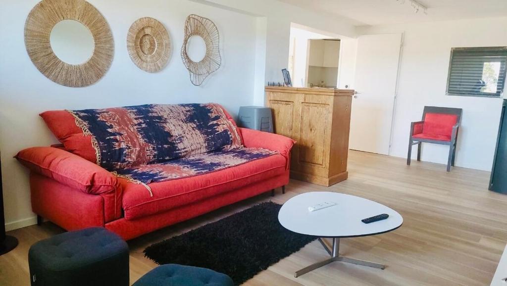 a living room with a red couch and a table at Appartement Cozy in Le Monteil