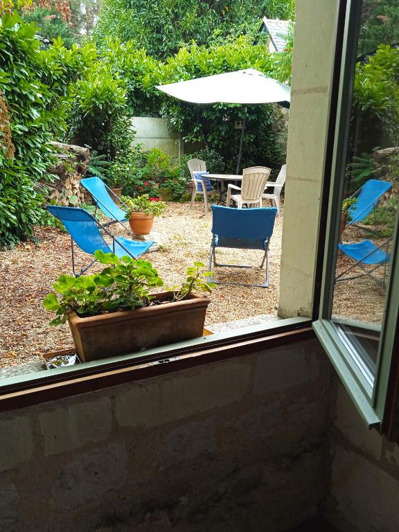 an outside window with chairs and a table and chairs at La Closerie in Saint-Philbert-du-Peuple