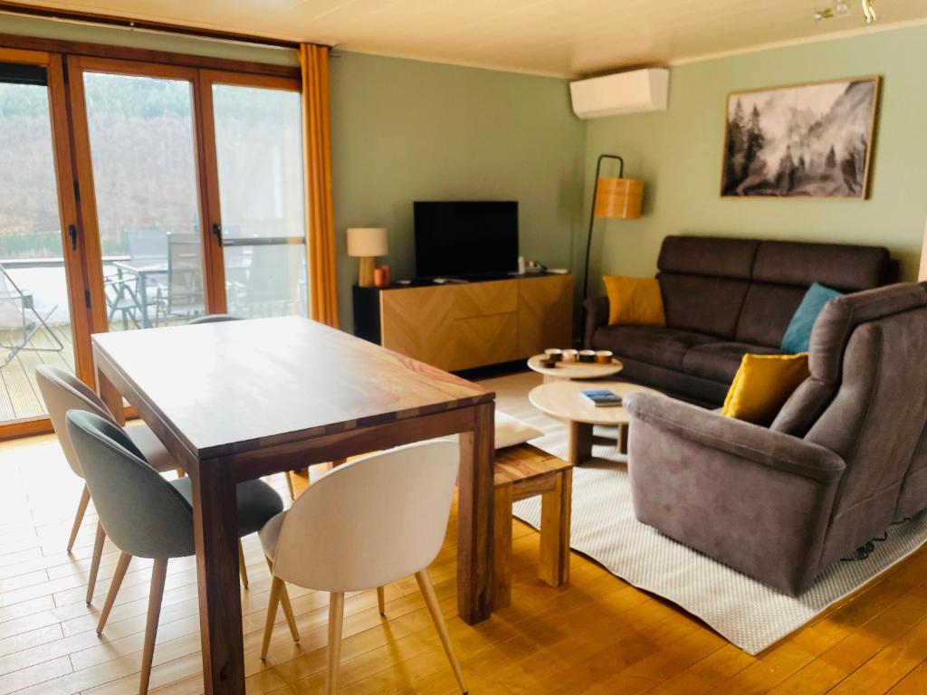 a living room with a couch and a table and chairs at Le lit de la Semois in Vresse-sur-Semois