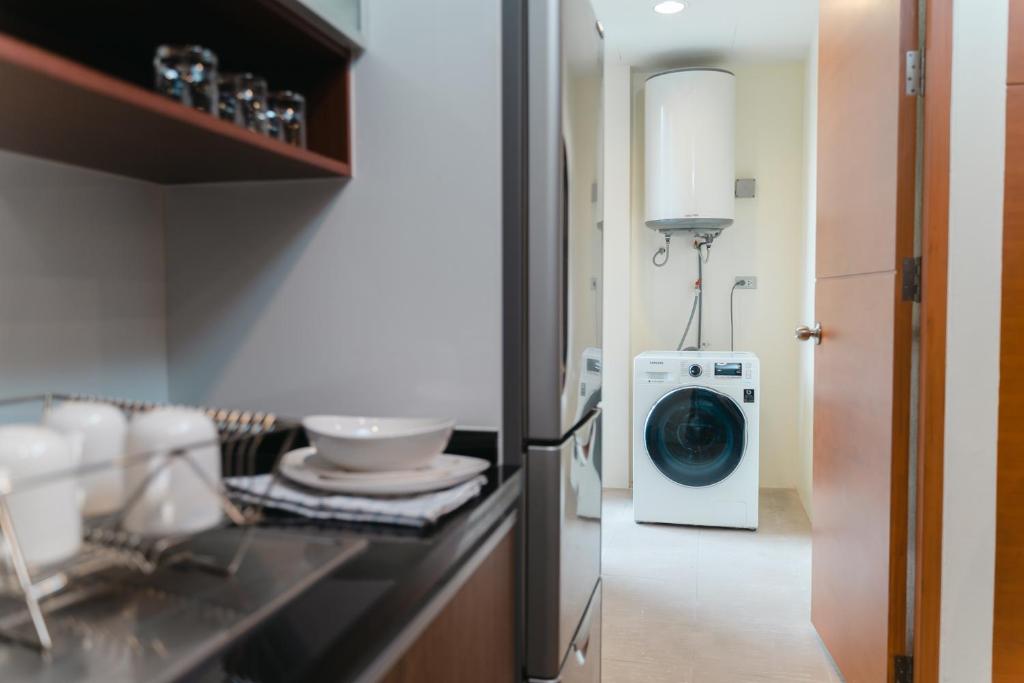 A compact kitchenette with a washer-dryer and hot-water tank.