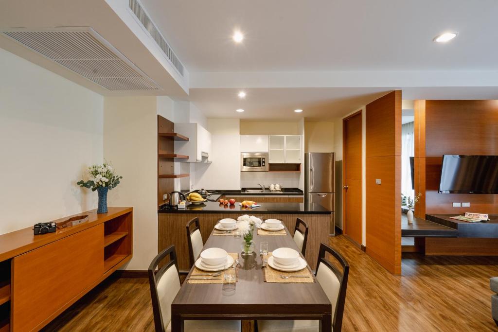 A furnished dining area beside an open residence kitchen and living room.