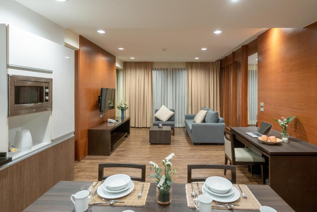 An open-plan living and dining room with a compact kitchen and work desk.