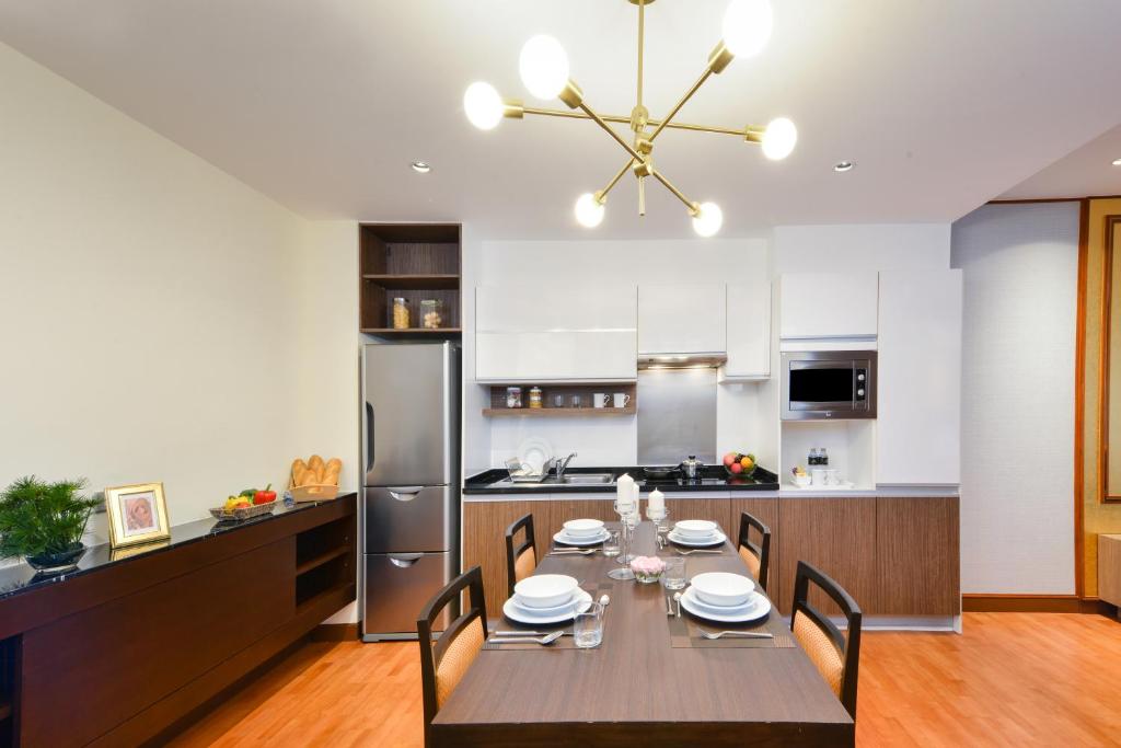 A dining area set for four beside a compact fitted kitchen.