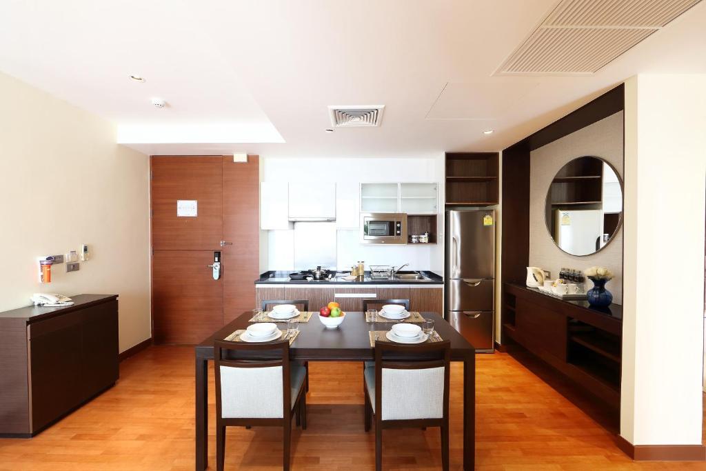 A fully equipped apartment kitchen beside a four-seat dining table.