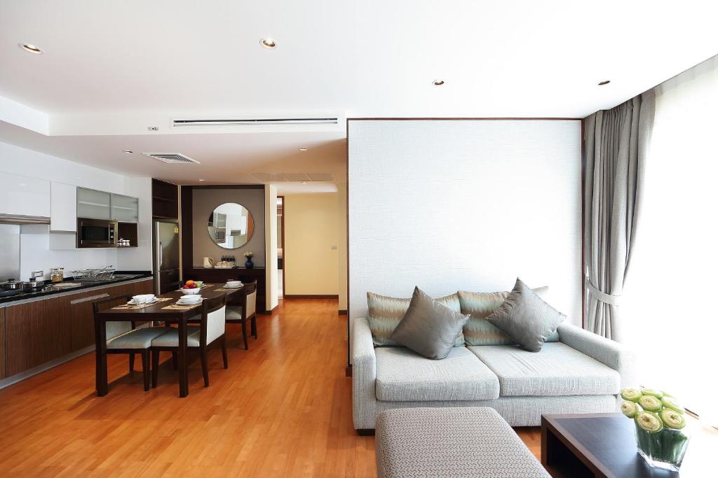 An open-plan residence living area with a sofa, dining table, and kitchenette.