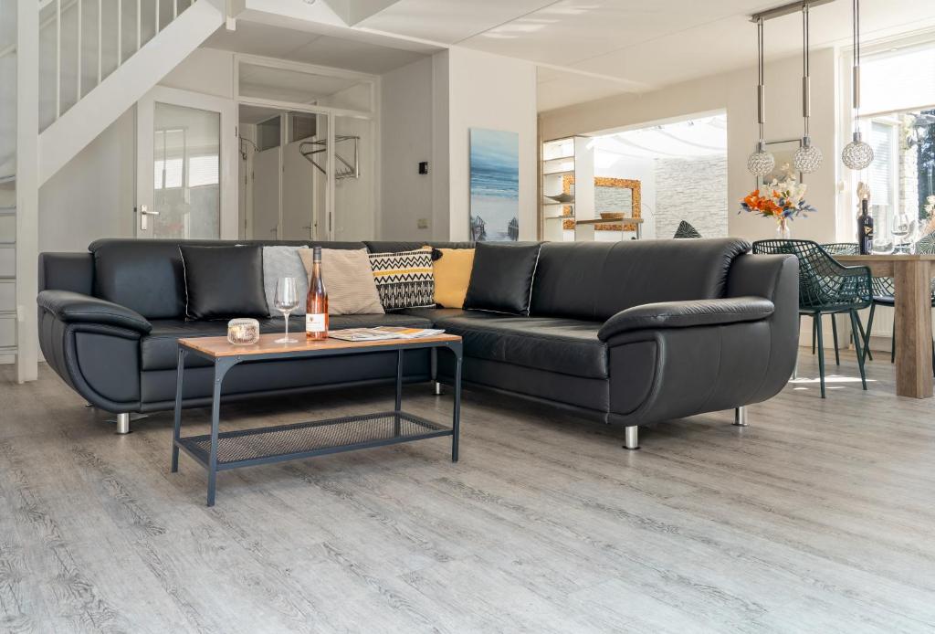 a living room with a couch and a table at Villa Beach & Spa in Julianadorp