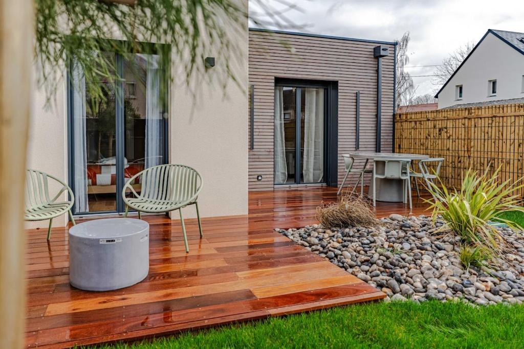 a wooden deck with chairs and a table on a house at Coquelicot in Caen