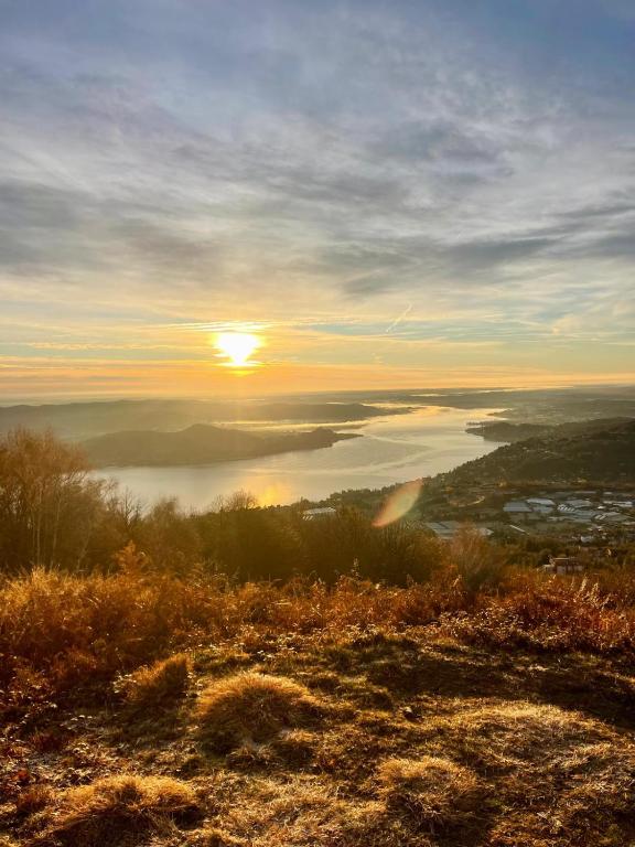 a view of a sunset from a hill with a lake at CT ROOMs in Invorio Inferiore