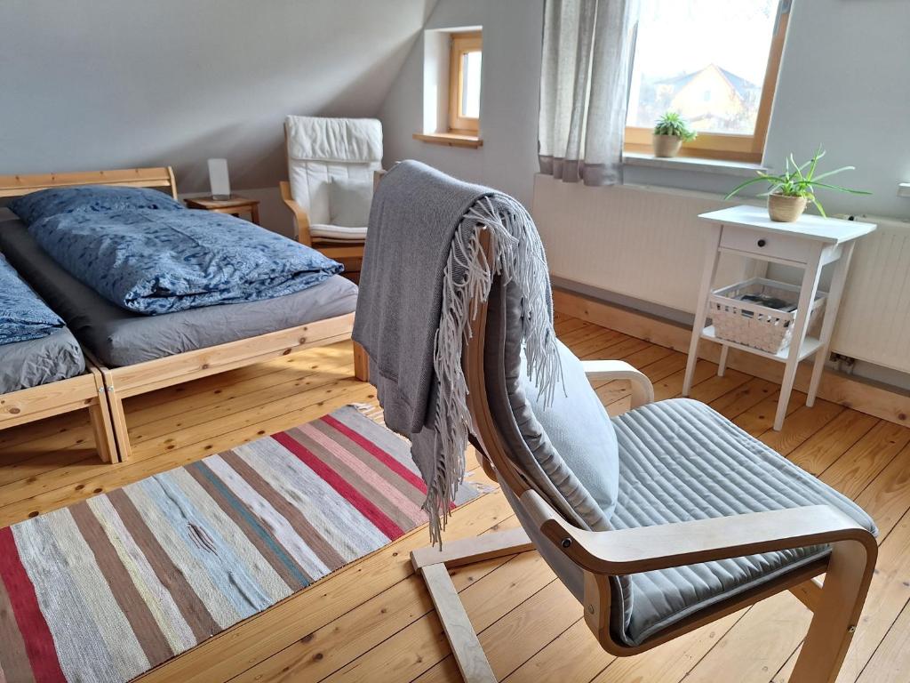 a bedroom with a chair and a bed and a rug at Ferienwohnung am Auenweg in Milstrich Oßling