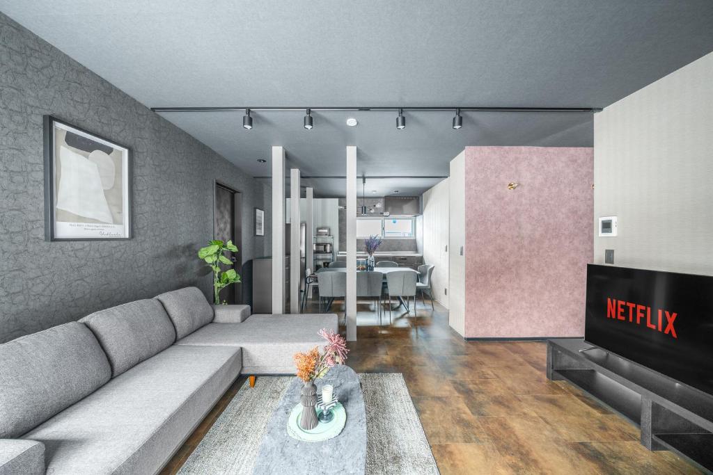 a living room with a couch and a table at Prunoia in Furano