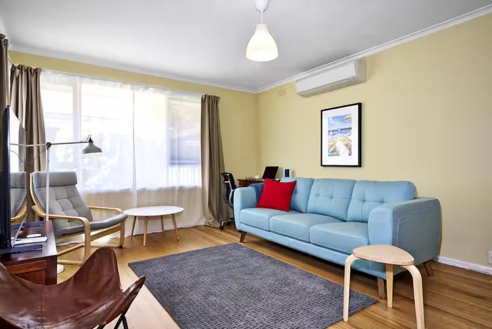 a living room with a blue couch and a table at Hampton Beach House in Melbourne